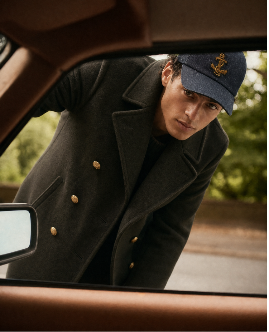 Peacoat scuro e cappellino Sealup, un ritratto in automobile